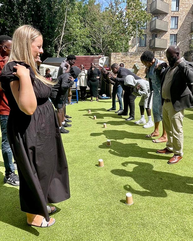 The church family gathered on the lawn after a service, laughing together during an outdoor game
